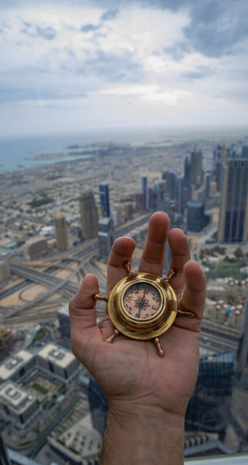 Hand holding compass in Dubai city Hand holding compass in Dubai city