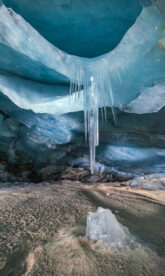 Huge icicle hanging from an ice cave ceiling