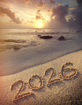 The year 2026 written on the sandy beach by twilight