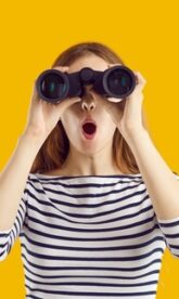 What,Is,There.,Curious,And,Inquisitive,Woman,Peeking,Through,Binoculars